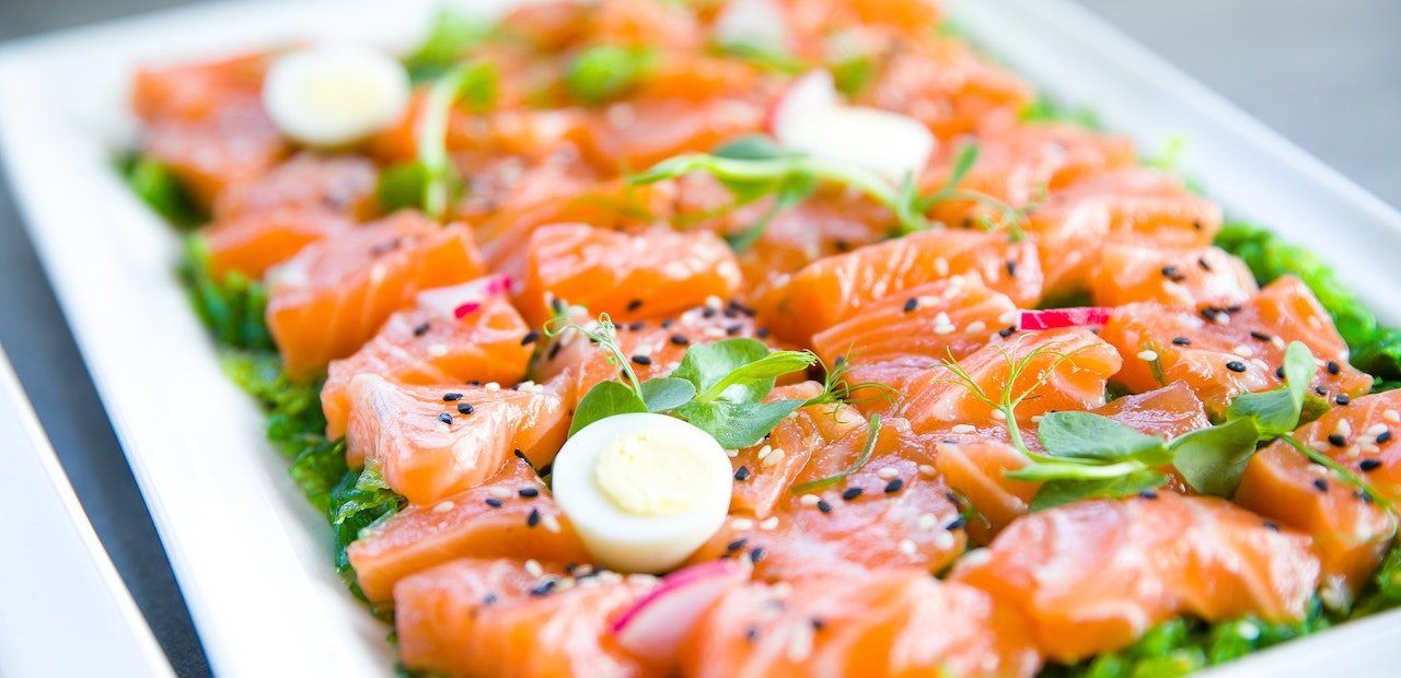 Ein zubereiteter Lachs, schön auf einem frischen Salat angerichtet.